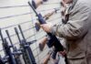 Person examining a black rifle in a gun store