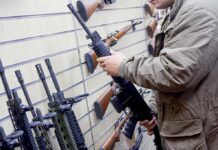 Person examining a black rifle in a gun store