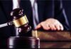 Graphic Autopsies Rattle Massachusetts Court Judge's gavel striking block with hand on book in background