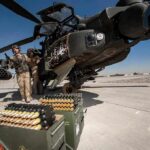 Trump Says America’s Arsenal Remains Strong attack helicopter on tarmac with crew and ammunition crates
