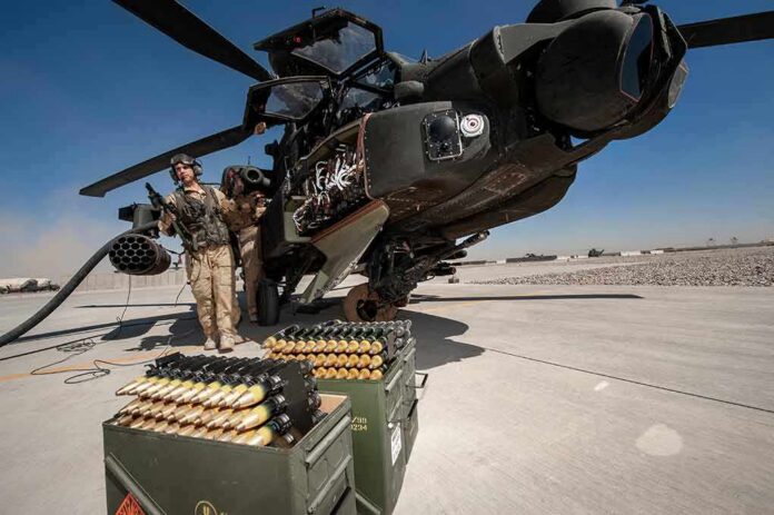 attack helicopter on tarmac with crew and ammunition crates