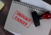10% Wall Slams Imports—What Gets Hit Next? Notebook with import tariff stamp and red-handled rubber stamp