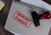 10% Wall Slams Imports—What Gets Hit Next? Notebook with import tariff stamp and red-handled rubber stamp