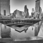 Pentagon Over Ground Zero — Here’s Why A memorial water feature surrounded by tall buildings in a city