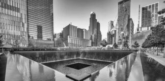 A memorial water feature surrounded by tall buildings in a city