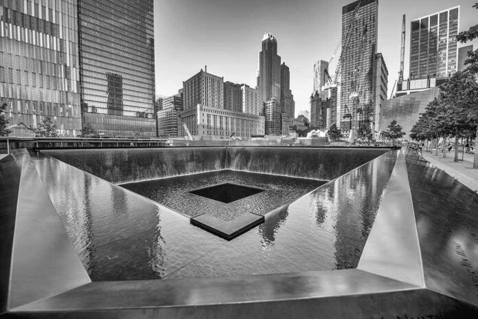 A memorial water feature surrounded by tall buildings in a city
