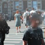 Biometric Dragnet Hits Italy’s Streets Crowd crossing a city street with digital tracking overlays