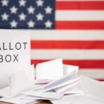 Michigan Meltdown After Razor-Thin Loss Ballot box with papers in front of an American flag