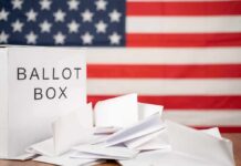 Michigan Meltdown After Razor-Thin Loss Ballot box with papers in front of an American flag