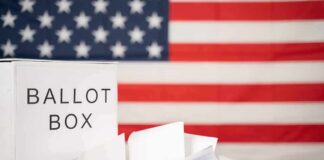 Ballot box with papers in front of an American flag