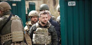 man in tactical vest walking with soldiers