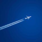 Transatlantic Flights Enter a New Climate Experiment Airplane leaving contrails in a clear blue sky