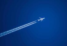 Transatlantic Flights Enter a New Climate Experiment Airplane leaving contrails in a clear blue sky