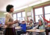 Connecticut Put Religion Into Law. Critics Pounced Teacher engaging with students raising hands in a classroom