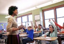 Connecticut Put Religion Into Law. Critics Pounced Teacher engaging with students raising hands in a classroom