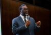 Parks, Schools Off-Limits—Arrests Halted Man in a suit speaking into a microphone