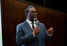 Man in a suit speaking into a microphone