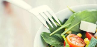 Salad with spinach, cherry tomatoes, corn, and feta in a bowl
