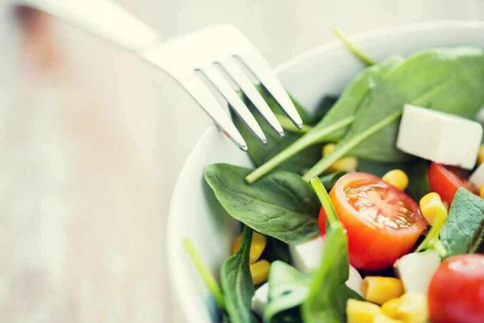 shutterstock_374635276 Salad with spinach, cherry tomatoes, corn, and feta in a bowl
