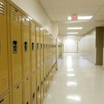 Row of yellow school lockers in an empty hallway