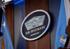 War Costs Are Quietly Rewriting The Pentagon Budget The Pentagon emblem between two flags.