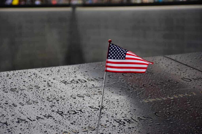 American flag on a rainy memorial nameplate.
