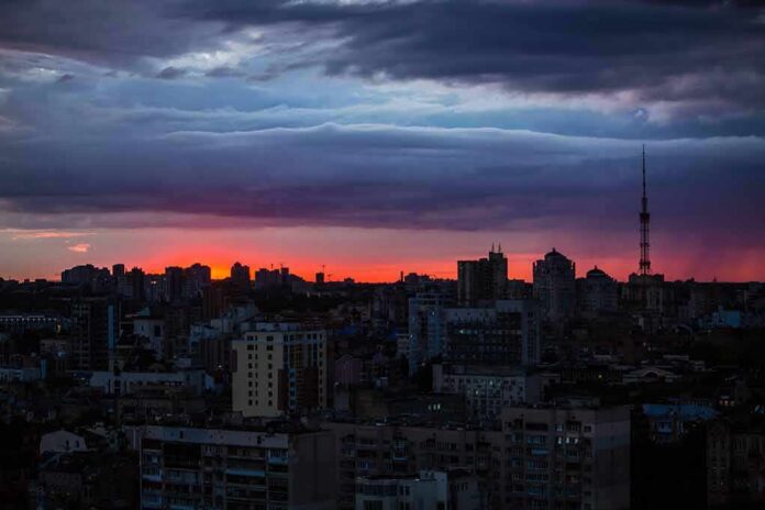 city skyline at dusk with dramatic clouds and orange horizon
