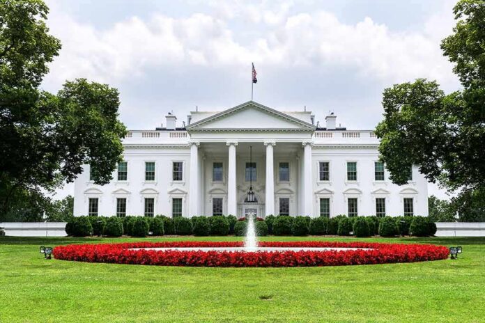 shutterstock_1016809915 The White House with fountain and red flower bed