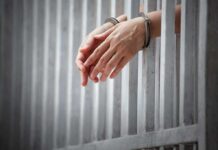 Misdemeanor Battery Rocks YouTuber handcuffed hands resting through prison bars