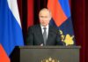Vladimir Putin speaking at a podium with microphones