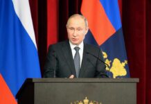 What Moscow Wanted Was Bigger Than The Border Vladimir Putin speaking at a podium with microphones