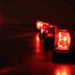 Row of red emergency beacons on a dark floor