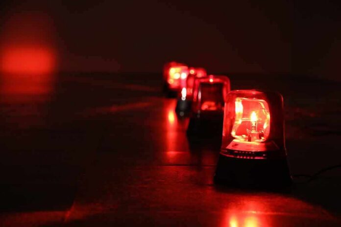 shutterstock_1041521929 Row of red emergency beacons on a dark floor