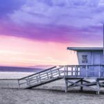 Quake Swarm Rattles L.A. – More Than 90 in ONE Day! Lifeguard tower on a sandy beach at sunset with colorful sky