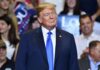 Rap Queen Joins Trump Cash Showdown Donald Trump at a rally wearing a dark suit and blue tie