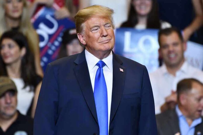 shutterstock_1151944724 Donald Trump at a rally wearing a dark suit and blue tie