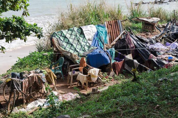 makeshift shelter near a beach with tarps and clothes drying