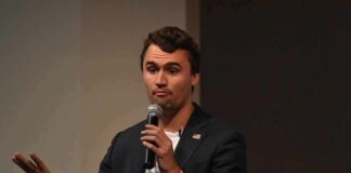 man speaking into a microphone on stage