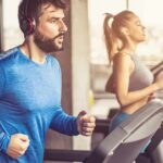 Healthy Gym-Goer Drops—Doctors Baffled Man in blue long-sleeve running on a treadmill with headphones