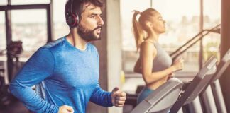 Man in blue long-sleeve running on a treadmill with headphones