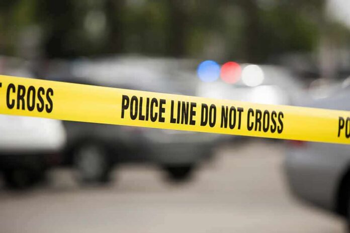 shutterstock_1482918374 Yellow police line tape at a blurred street scene