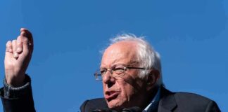 elderly man speaking at outdoor podium