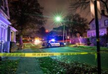 Sleeping Couple Ambushed – Why Him? Police car blocks residential street at night behind caution tape