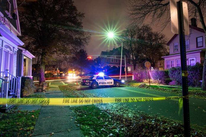 shutterstock_1793905801-1 Police car blocks residential street at night behind caution tape