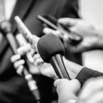 Microphones and recorders held toward a speaker