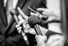 Microphones and recorders held toward a speaker