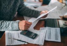Grid Spending Surge Pounds California Families Person reviewing bills with calculator at cluttered desk