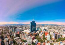 Global Heat Kill Count Stuns Researchers City skyline with tall blue-glass tower at center under clear sky