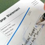 A person writing a check on a mortgage statement