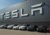 Robotaxi Showdown: Speed vs. Safety Tesla cars parked outside a large Tesla building